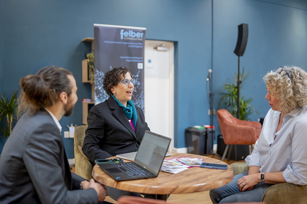 Three Felber team members sitting at the small table
